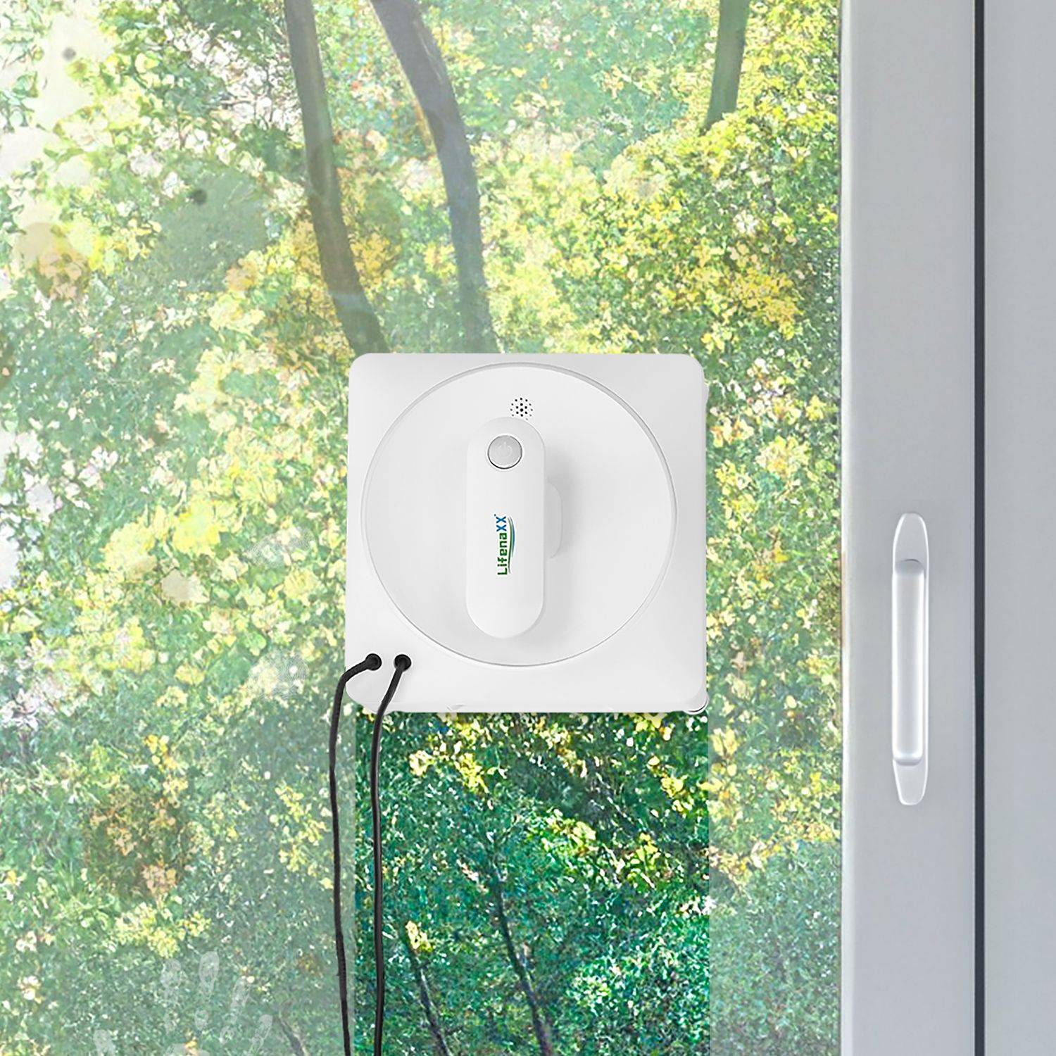 Fensterputzroboter an einer Glas-Schiebetür mit grünem Laub im Hintergrund