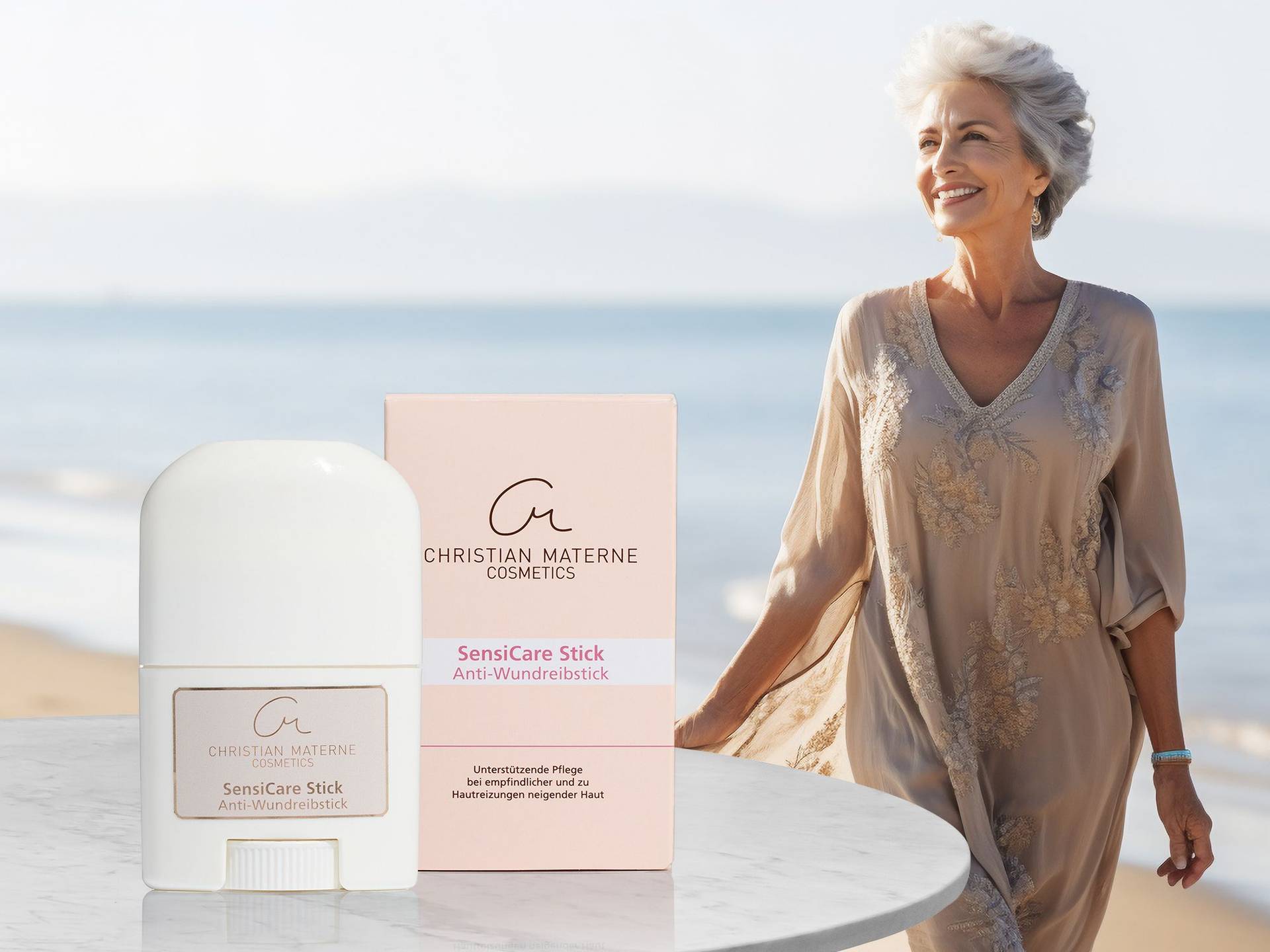 Christian Materne Cosmetics SensiCare Stick Anti-Wundreibstick mit Verpackung auf weißem Tisch, lächelnde ältere Frau im Hintergrund am Strand