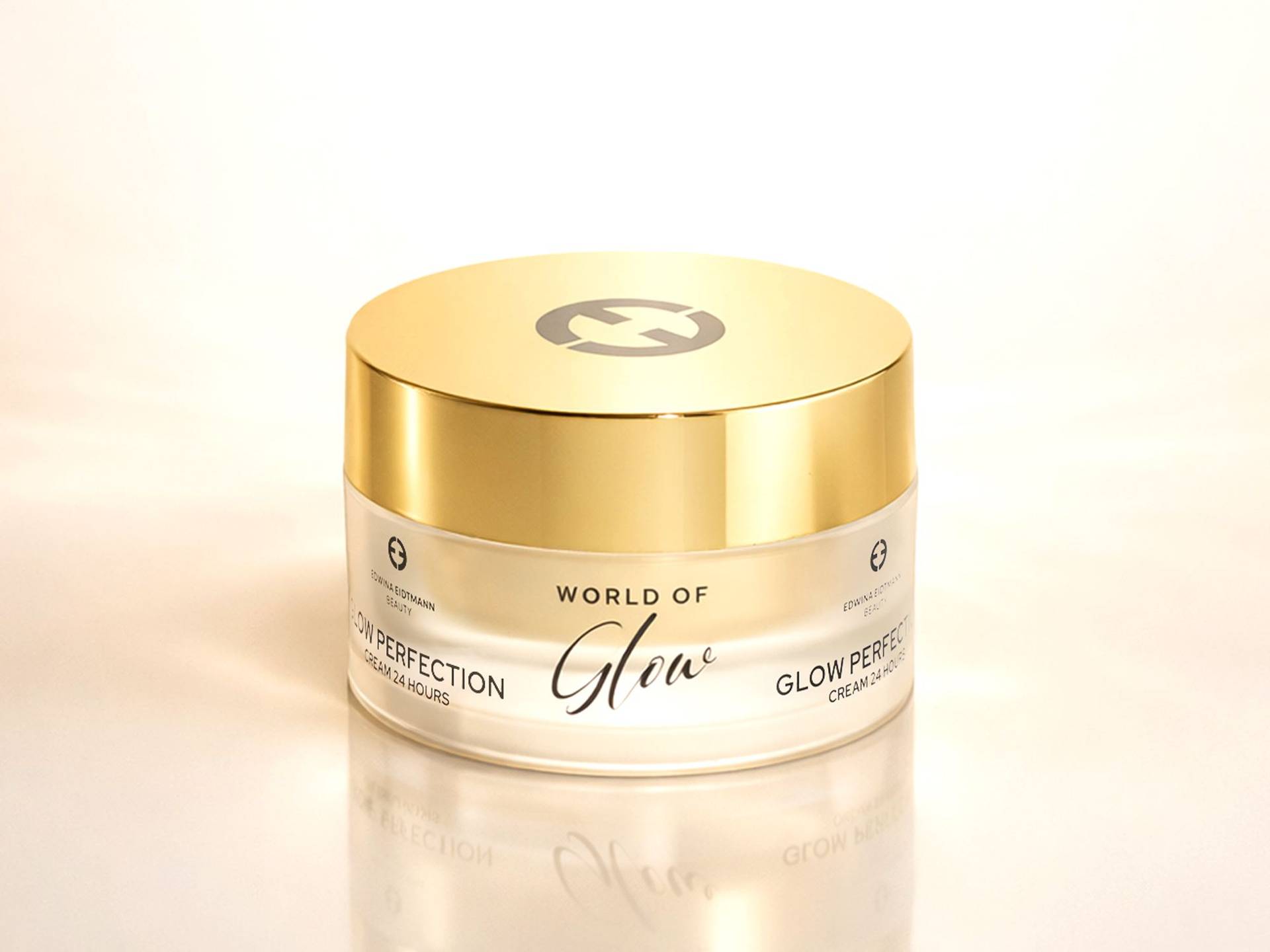 Runder Cremetiegel mit goldfarbenem Deckel und Aufschrift 'WORLD OF Glow'