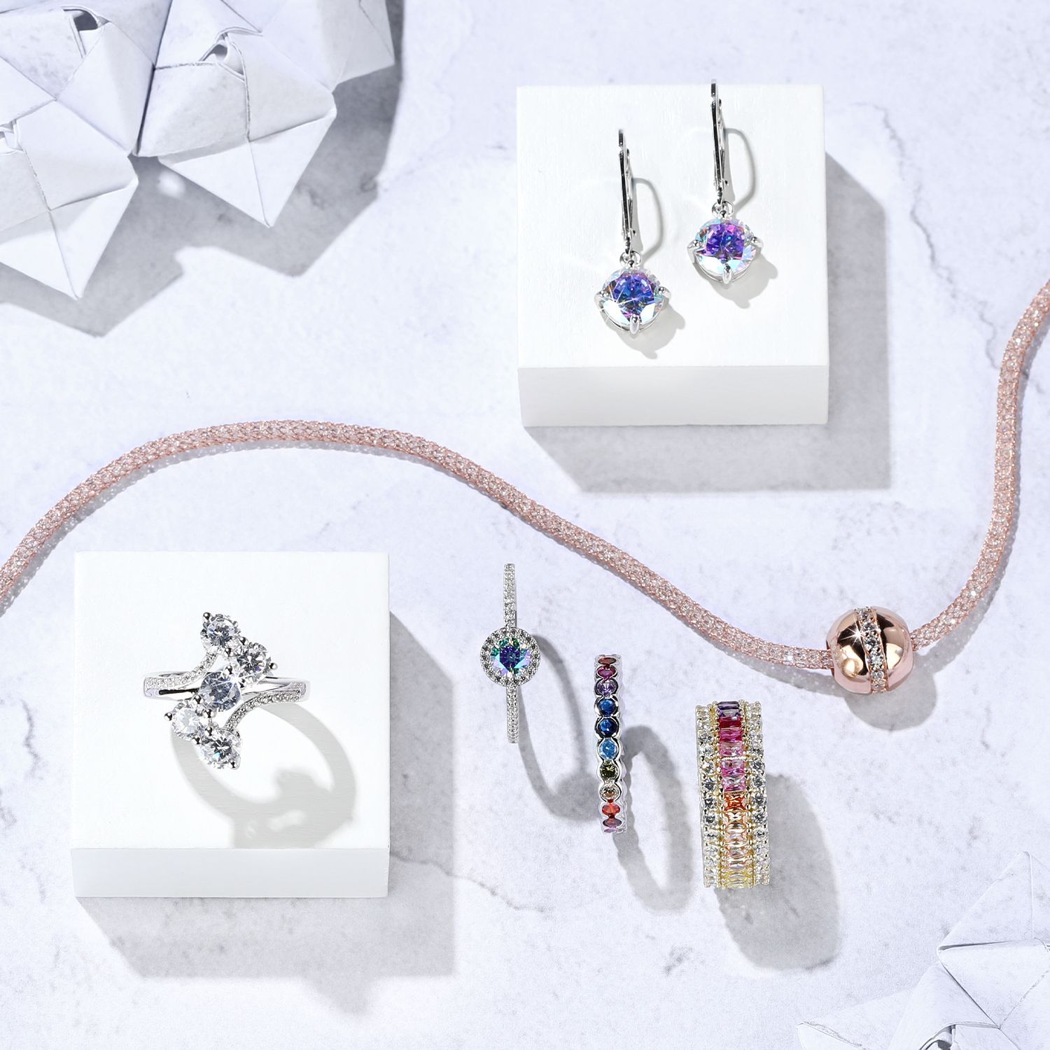 Schmuckset mit funkelnden Ringen und Ohrringen auf hellem Hintergrund