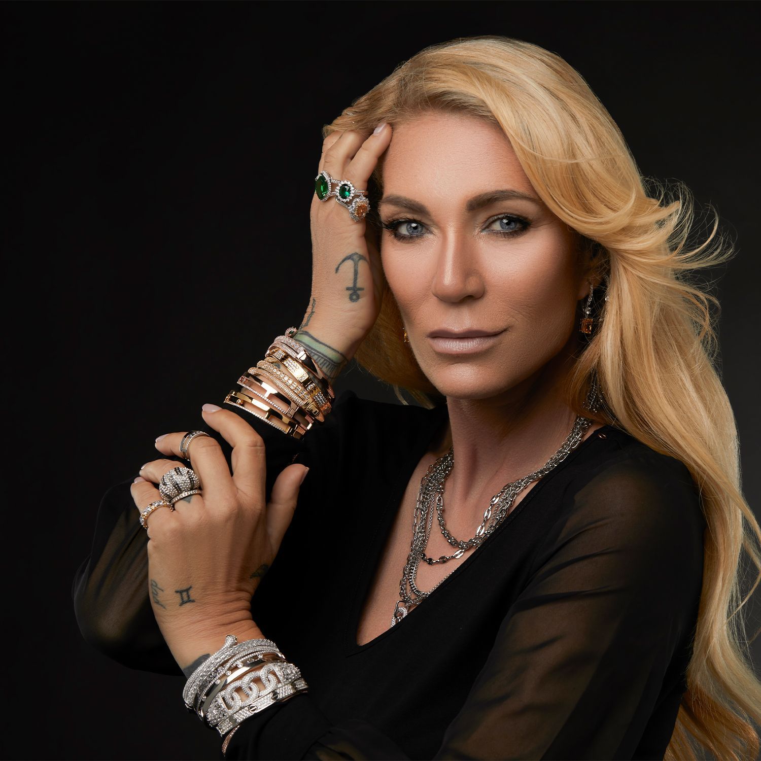 Frau mit elegantem Schmuck, präsentiert Armbänder und Ringe, CHANNEL21 Modekollektion.