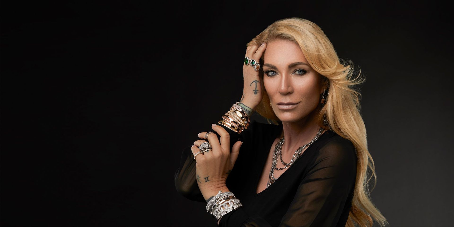 Frau mit elegantem Schmuck, präsentiert Armbänder und Ringe, CHANNEL21 Modekollektion.