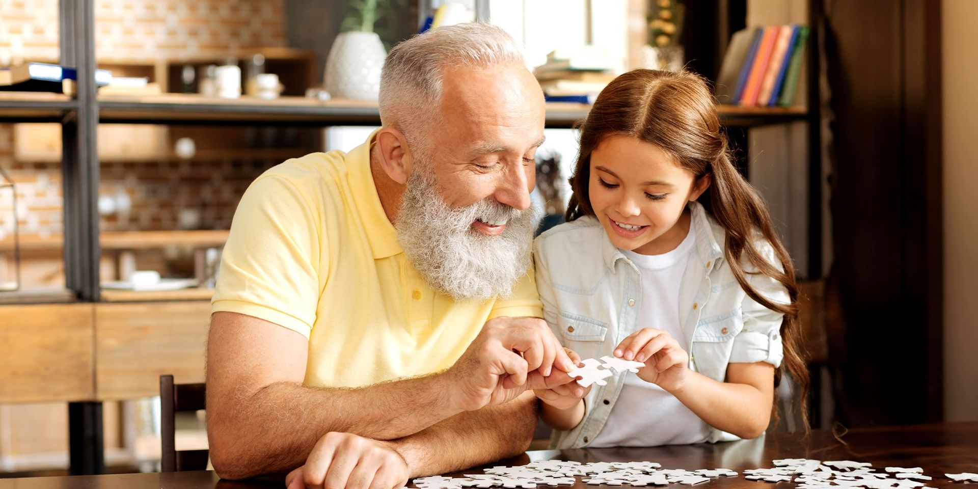 Älterer Mann und Kind beim Puzzeln, symbolisiert Mobilität und Freizeit im CHANNEL21-Kontext.