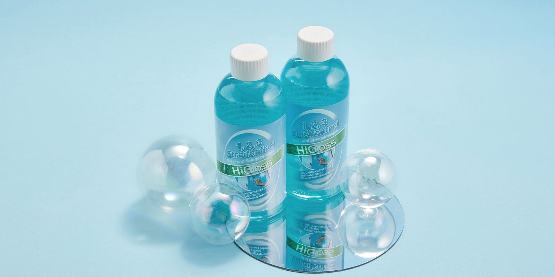 Zwei Flaschen HiGloss Reinigungsmittel mit Seifenblasen auf blauem Hintergrund