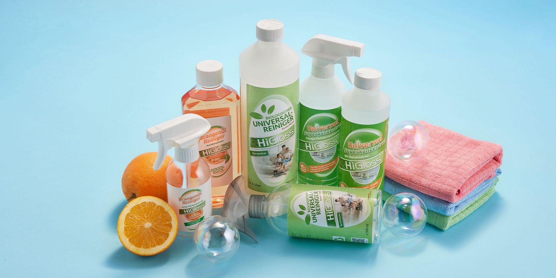 Verschiedene HiGloss Reinigungsprodukte mit Orangen auf blauem Hintergrund