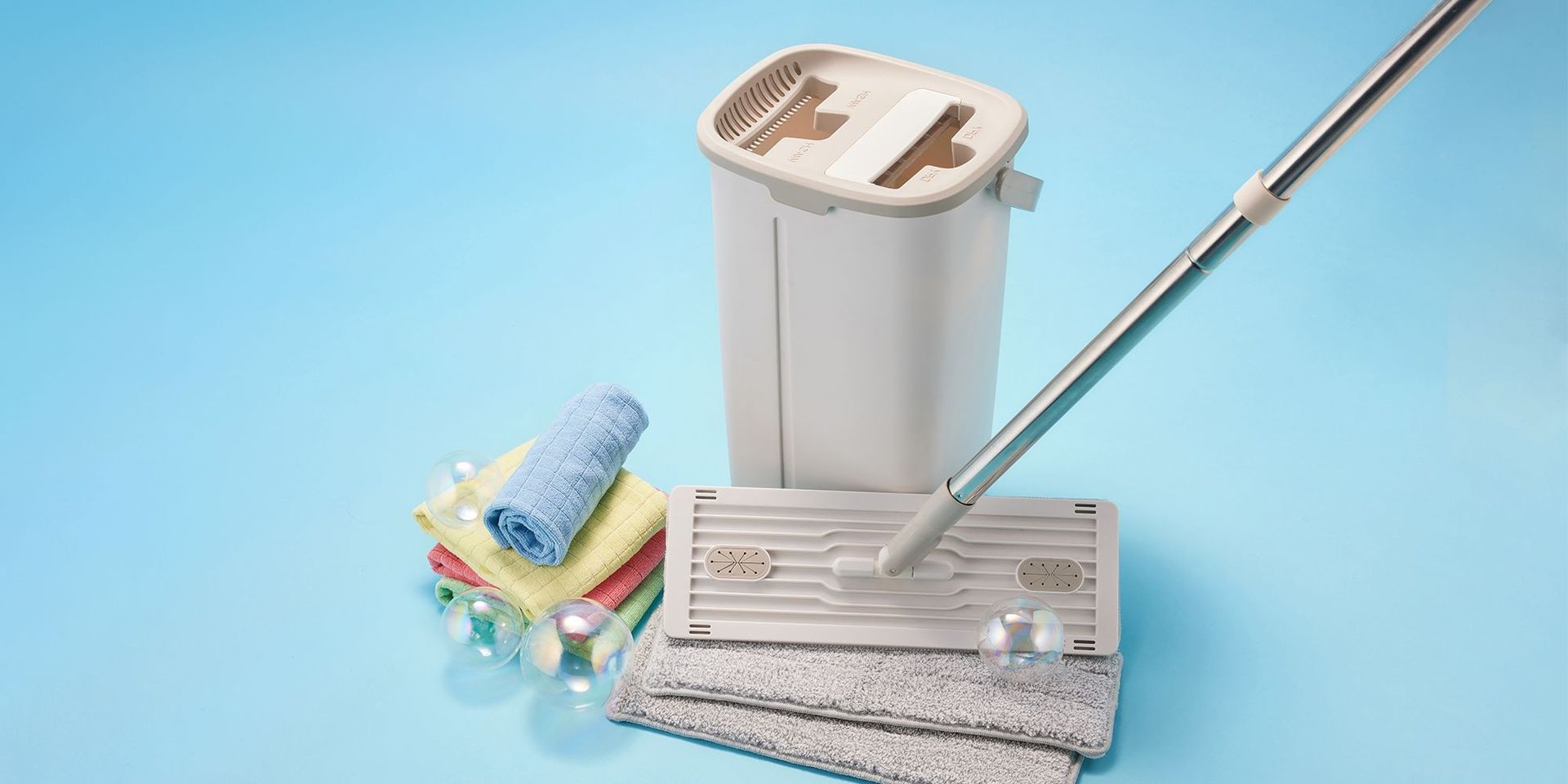 Reinigungsset mit Mopp und Tüchern auf blauem Hintergrund für Haushaltsprodukte bei CHANNEL21