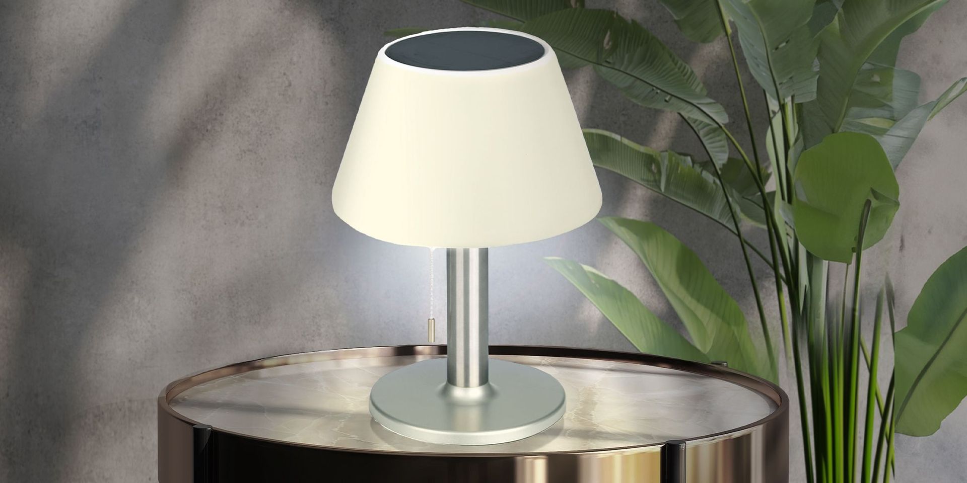 Moderne Tischlampe auf einem runden Tisch, umgeben von Pflanzen, im Kontext von Mobilität und Freizeit.