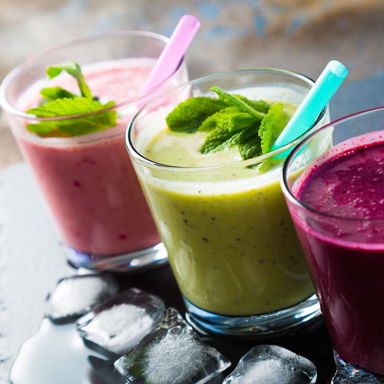 Drei Smoothies in Gläsern mit Strohhalmen.