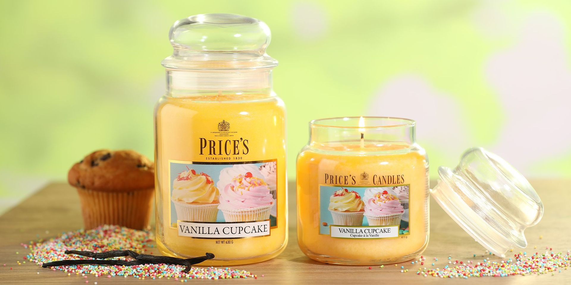 Kerzen im Vanille-Cupcake-Duft auf einem Tisch mit Streuseln im Hintergrund.