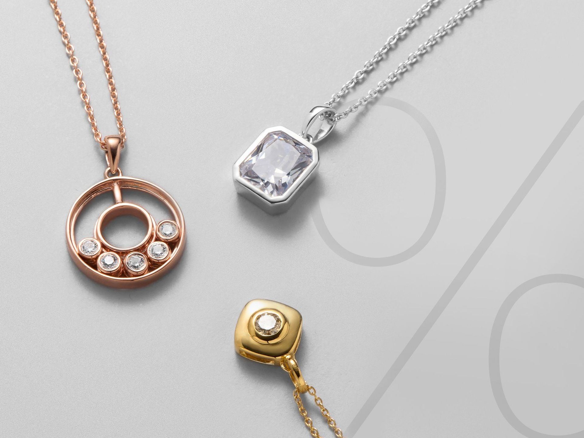 Drei Ketten mit Anhänger auf einem grauen Hintergrund