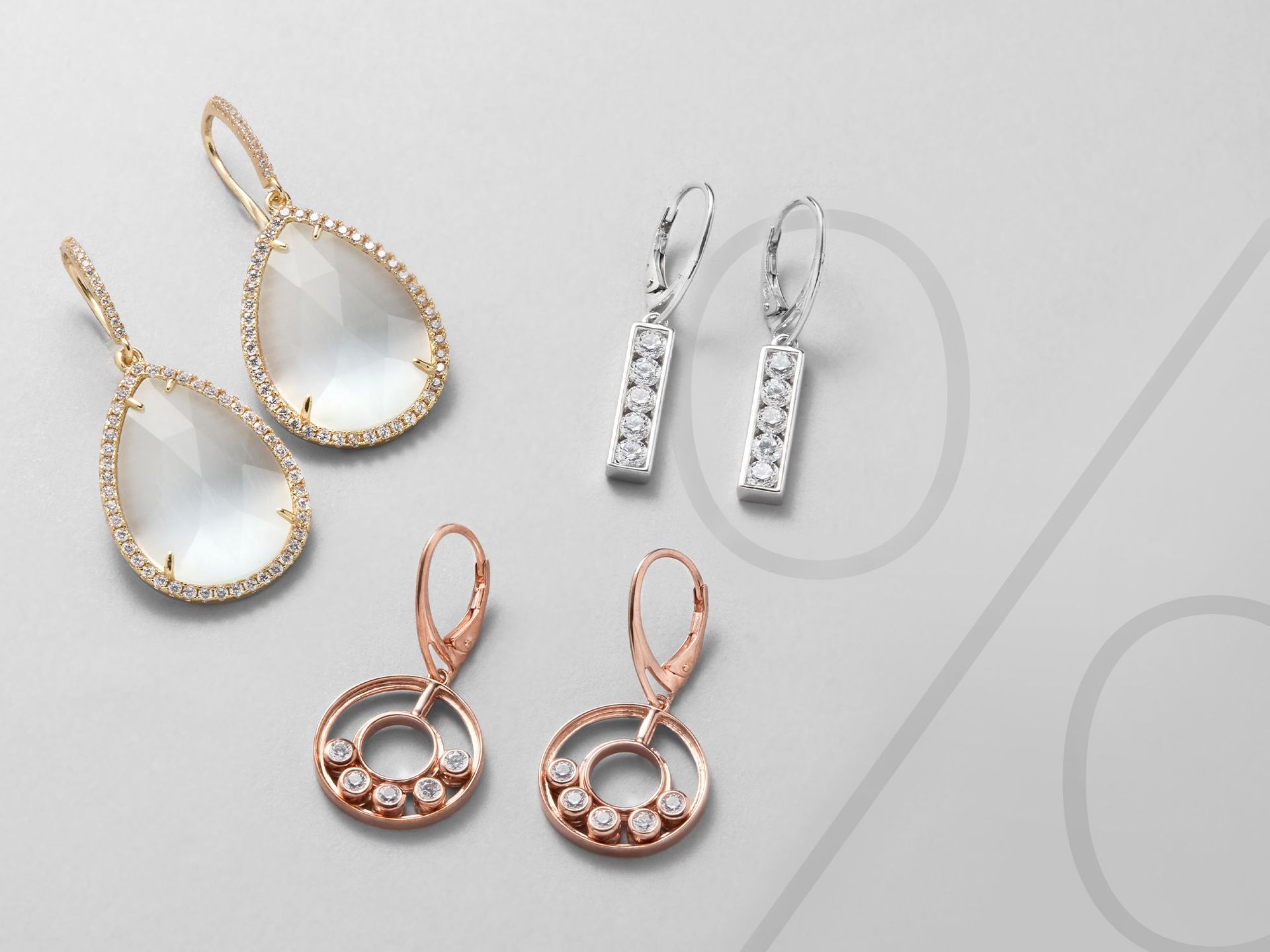 Drei Paare Ohrringe auf einem grauen Hintergrund