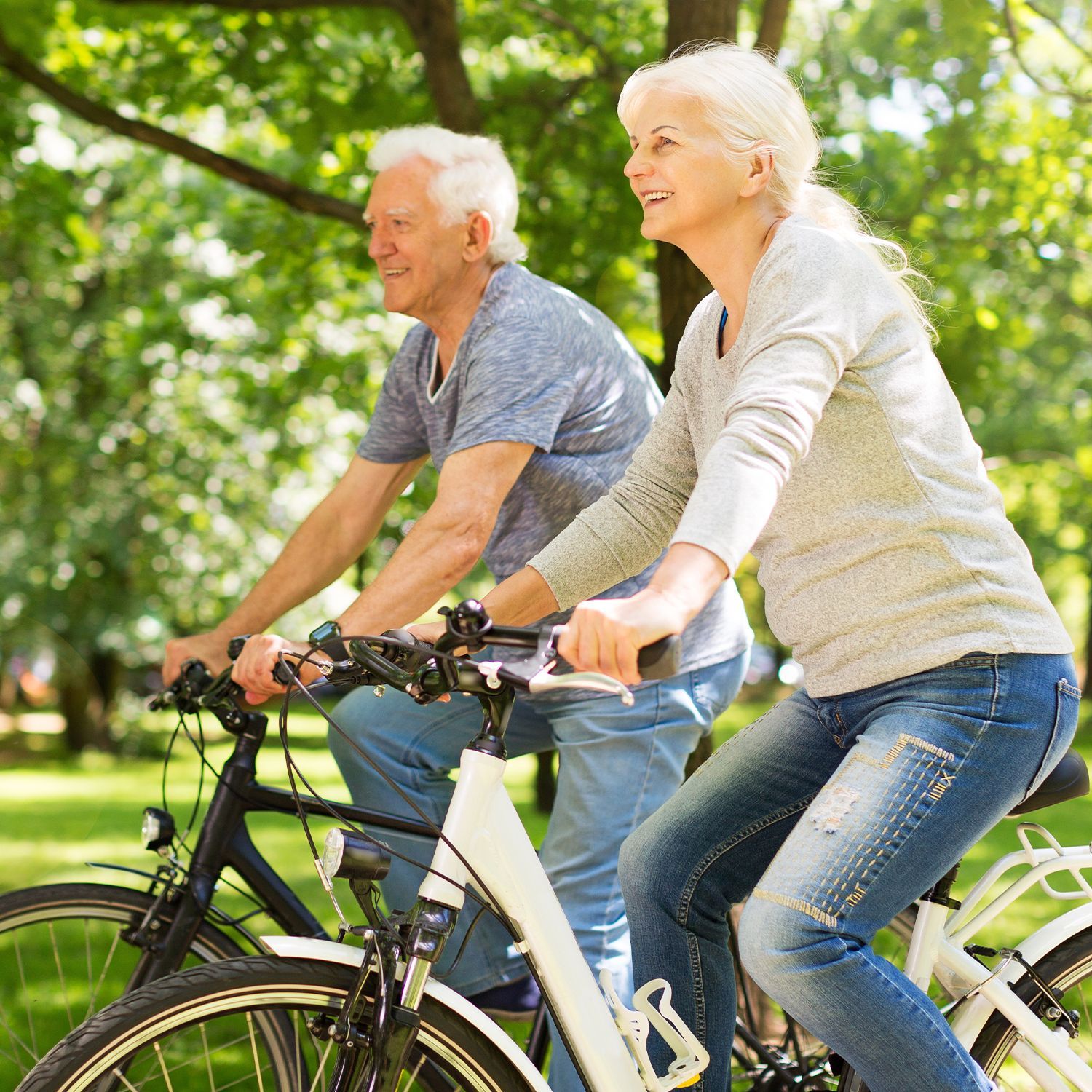 Älteres Paar fährt Fahrräder im Grünen, symbolisiert Mobilität und Freizeit für CHANNEL21.