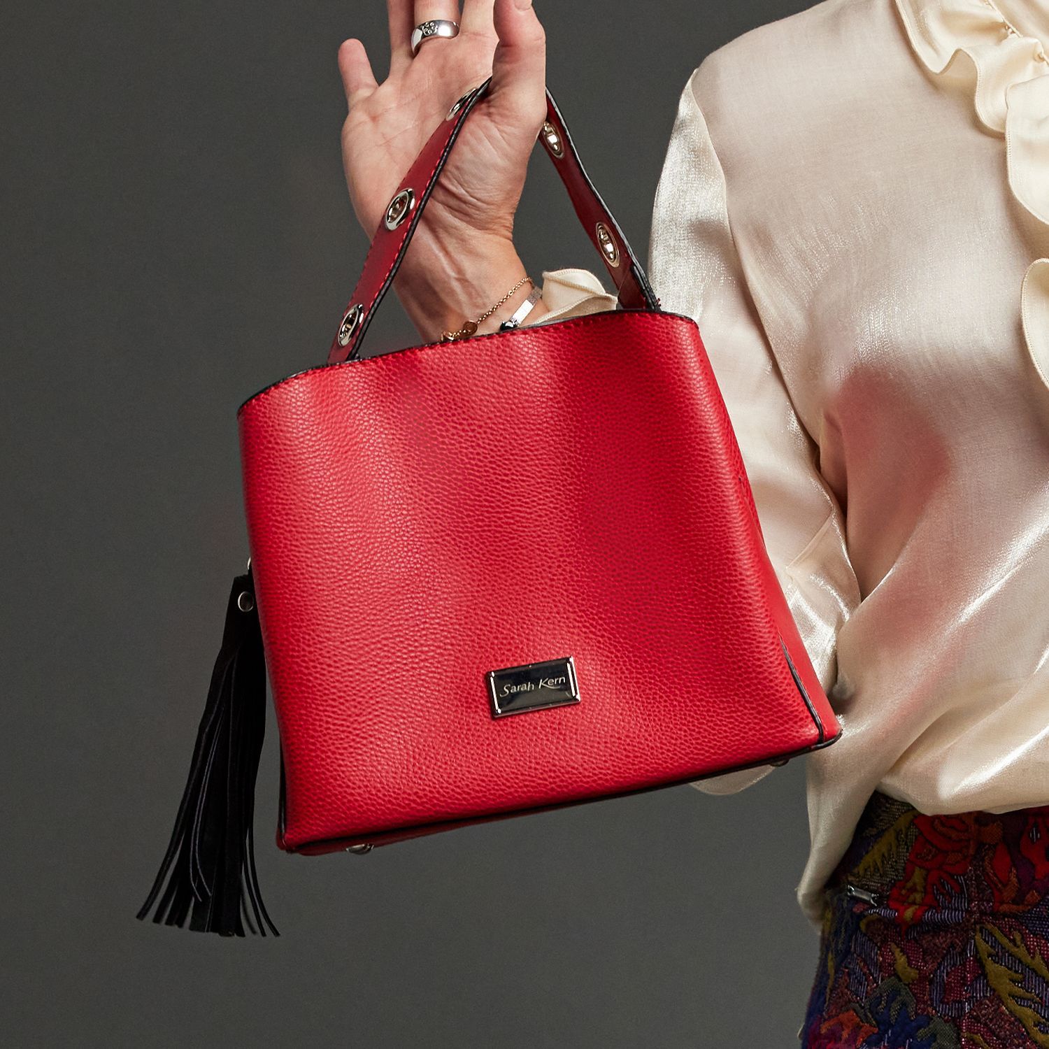 Frauenhand mit roter Tasche