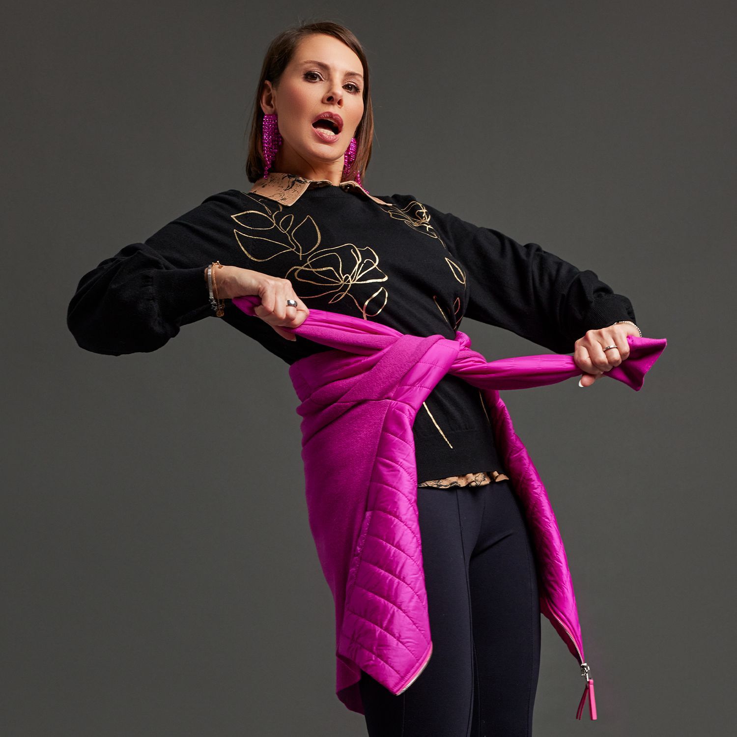 Model in schwarzer Kleidung mit pinker Jacke