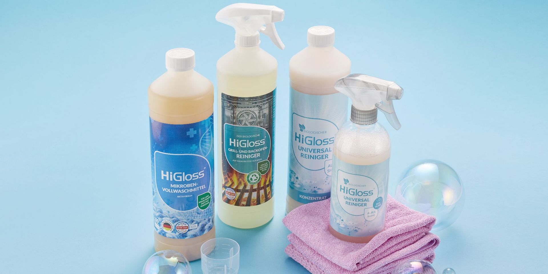 HiGloss Reinigungsmittel auf blauem Hintergrund mit Mikrofasertüchern und Seifenblasen