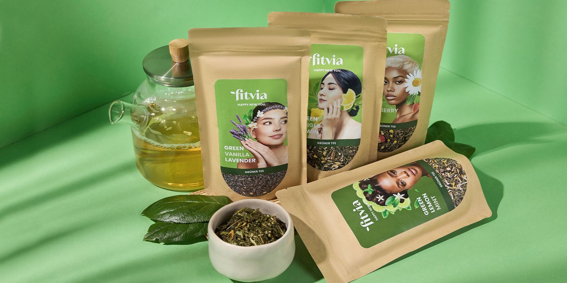 Verschiedene Fitvia-Teesorten mit grünem Tee und Kräutern auf grünem Hintergrund