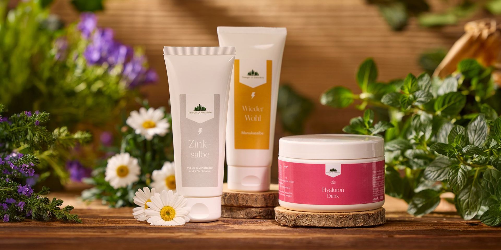 Pflegeprodukte mit Zinksalbe, Mandelcreme und Hyaluron-Drink auf Holzuntergrund