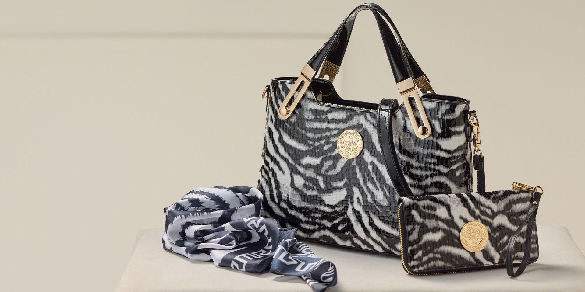 Zebra-Muster Handtasche und Geldbörse mit goldenen Details auf beigem Hintergrund