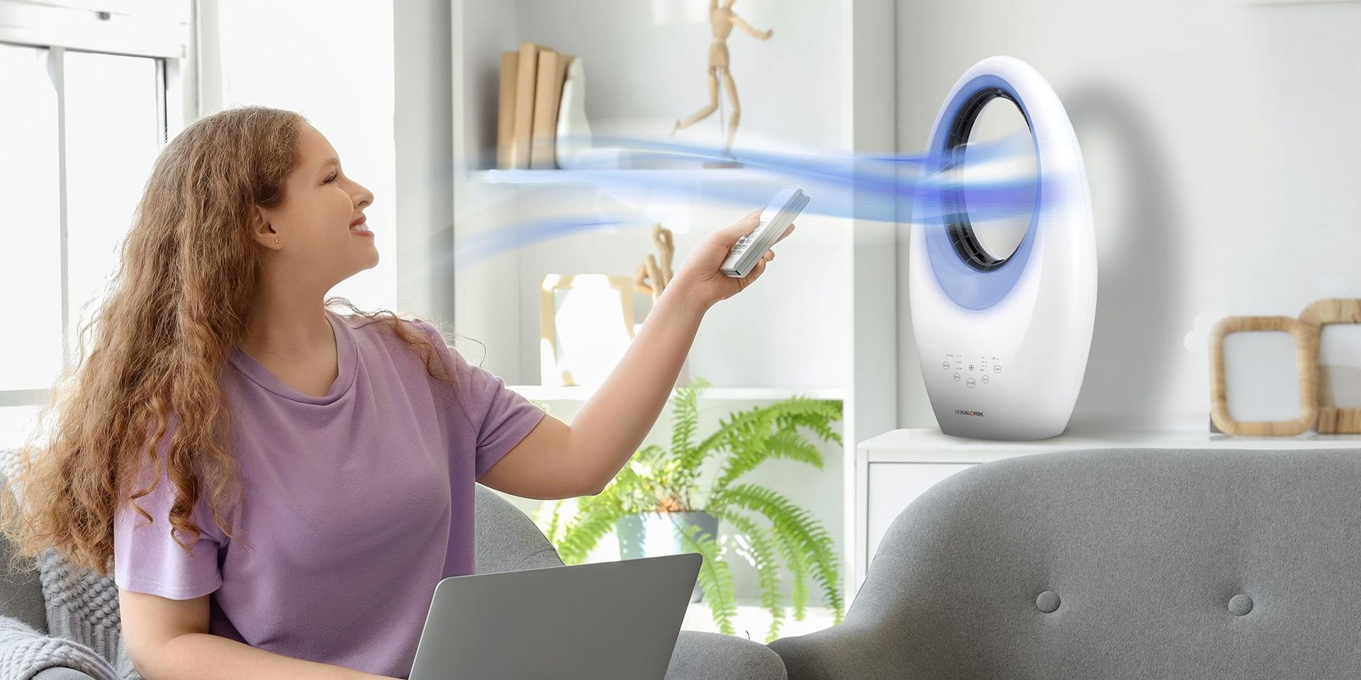 Frau schaltet einen Ventilator an, um sich abzukühlen