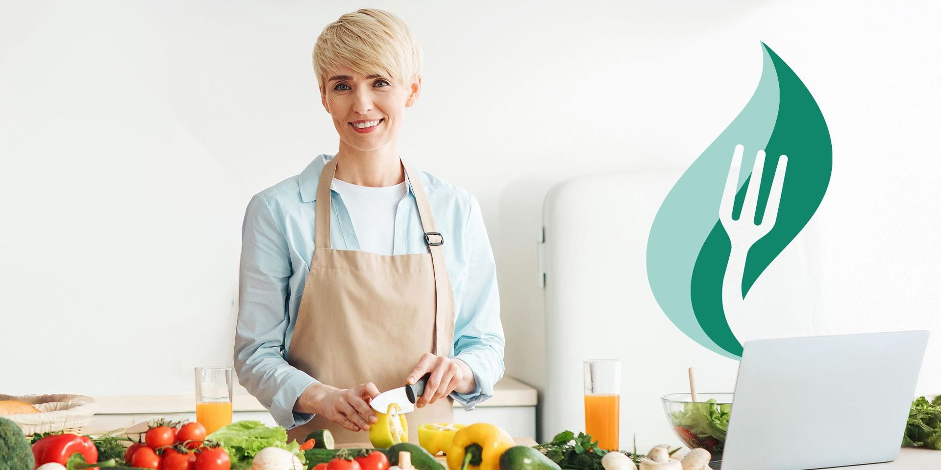 Person mit hellblondem Haar trägt beige Schürze und schneidet gelbe Paprika in moderner Küche mit frischem Gemüse und Laptop