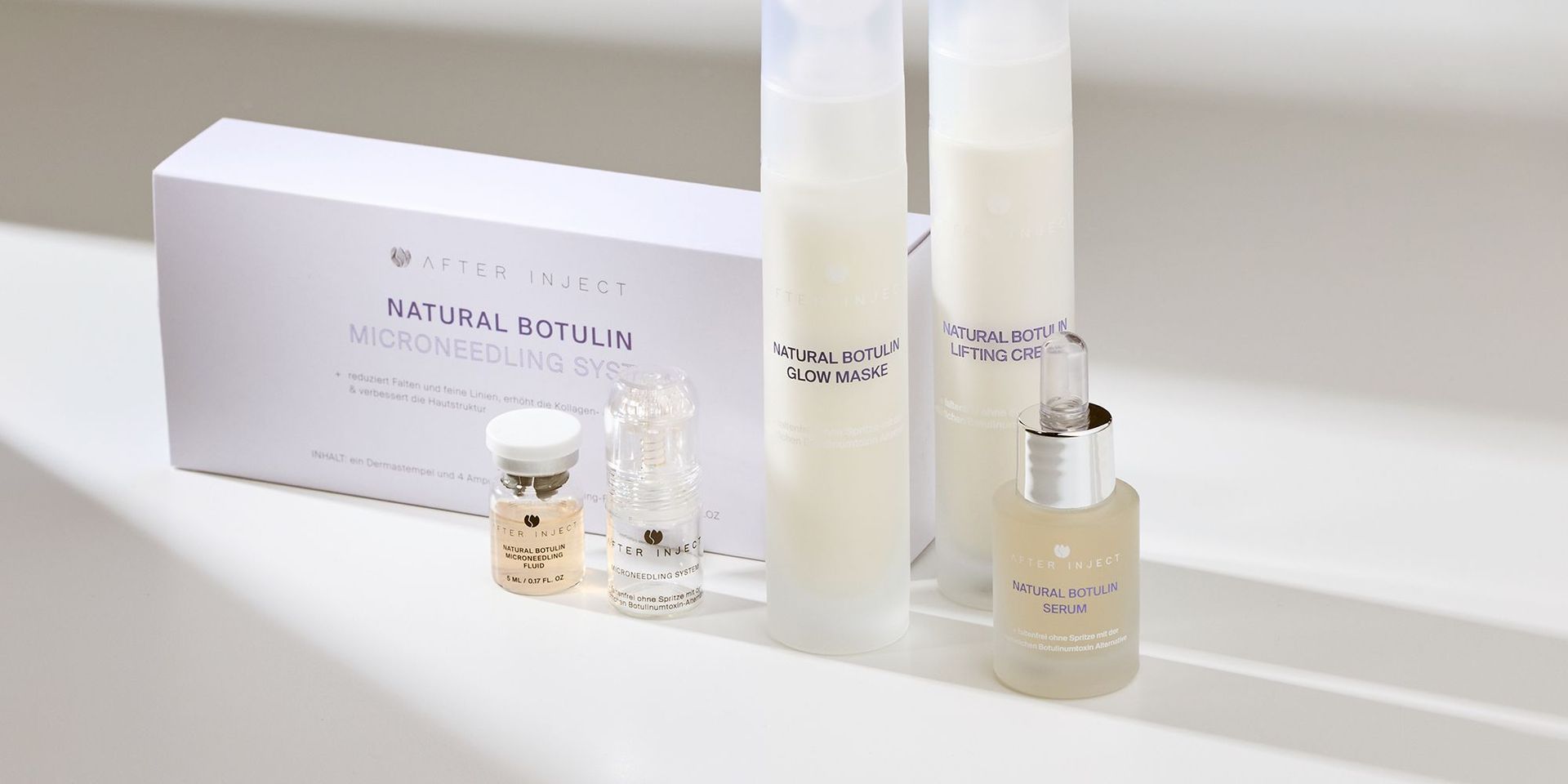 After Inject Produkte Natural Botulin Microneedling System, Glow Maske, Lifting Creme, Serum und zwei kleinen Fläschchen auf einem hellen Hintergrund