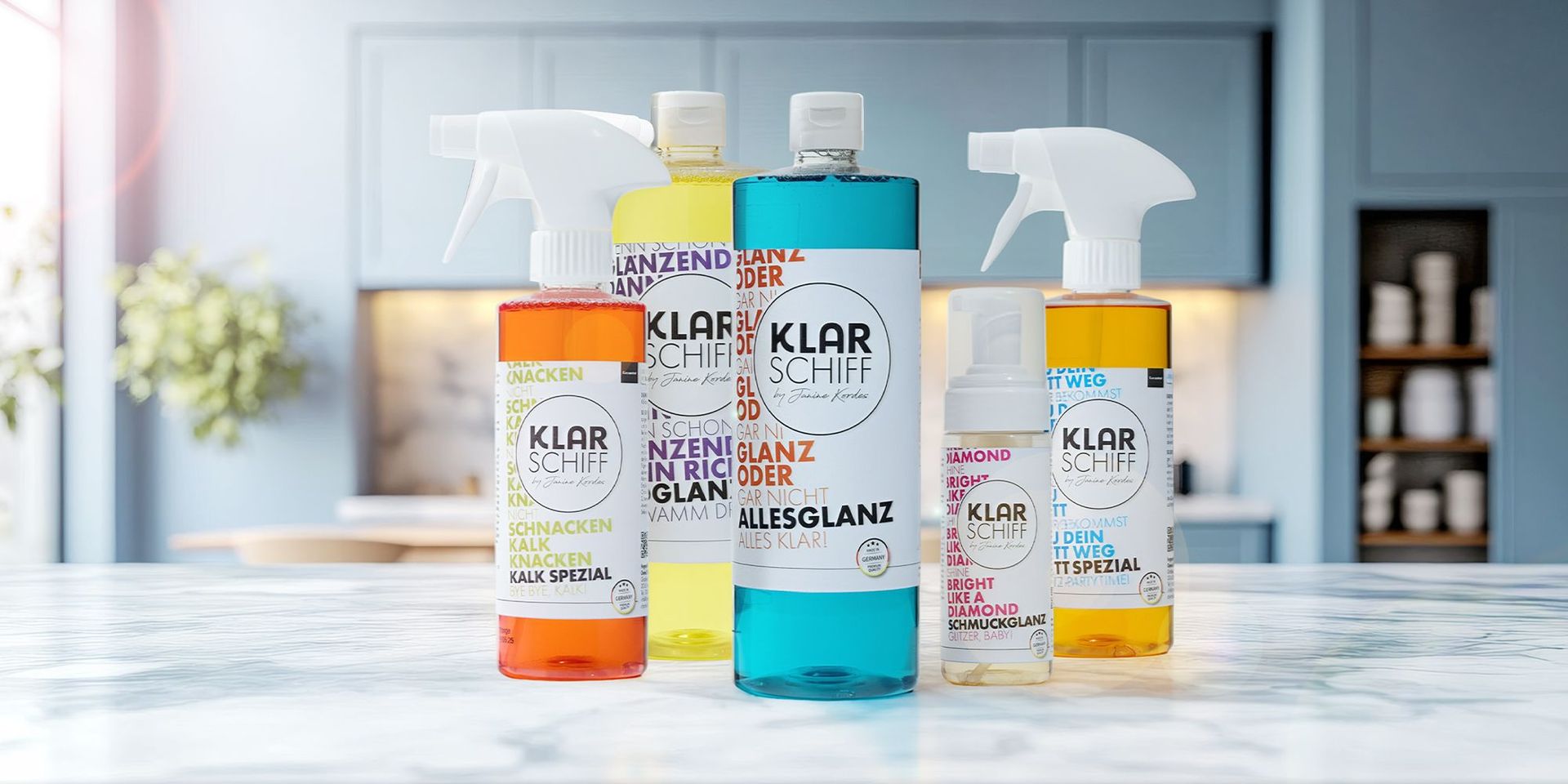 Fünf Reinigungsprodukte der Marke 'Klar Schiff' auf einer Arbeitsfläche. Produkte in verschiedenen Flaschenformen und Farben.