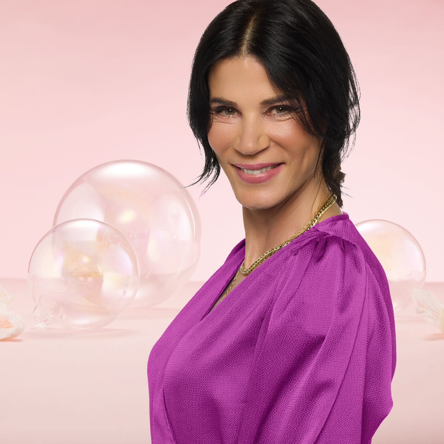 Linea Expertin Susanne Dethlefs vor pastellfarbenem Hintergrund mit transparenten Kugeln.