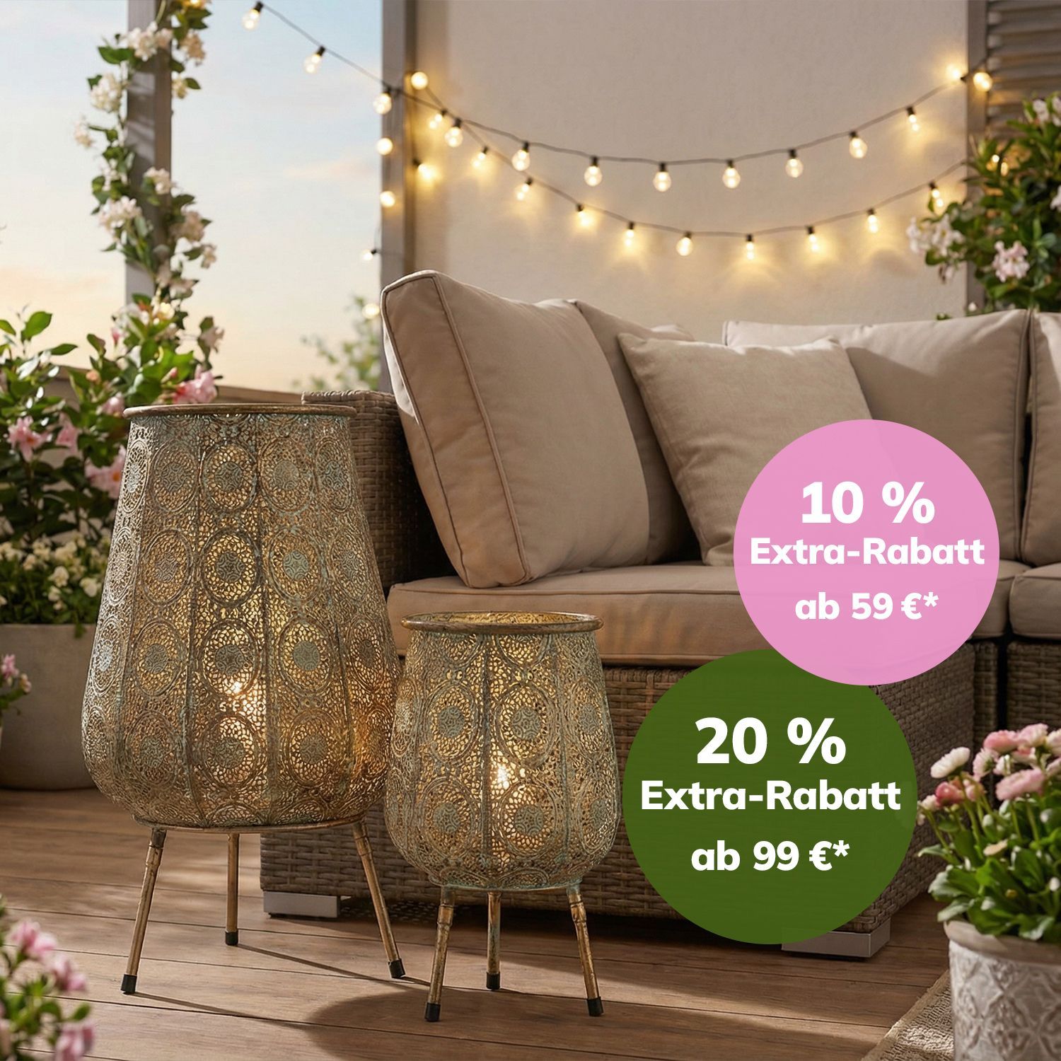 Terrassenmöbel aus Rattan mit hellen Polstern, umgeben von Pflanzen und dekorativen Laternen mit Lichterkette im Hintergrund