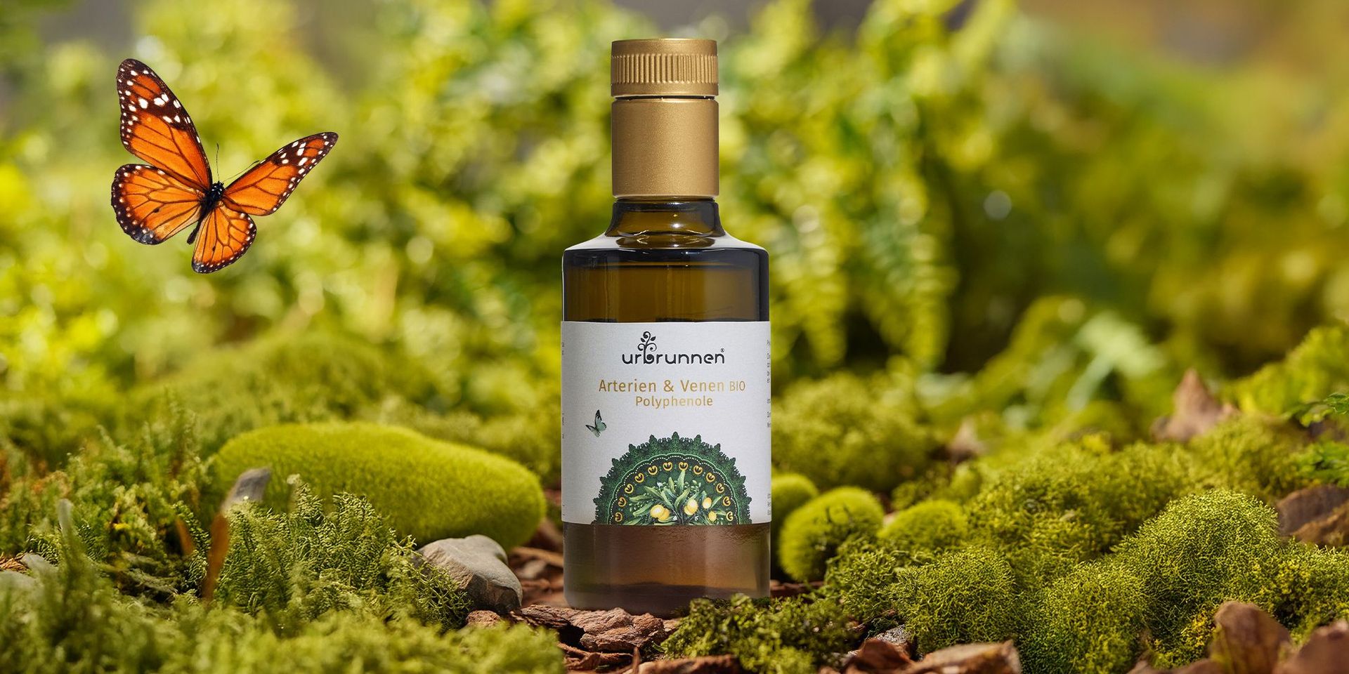Flasche mit goldfarbenem Verschluss und Etikett 'urbrunnen Arterien & Venen BIO Polyphenole' steht auf Moos mit orange-schwarzem Schmetterling daneben