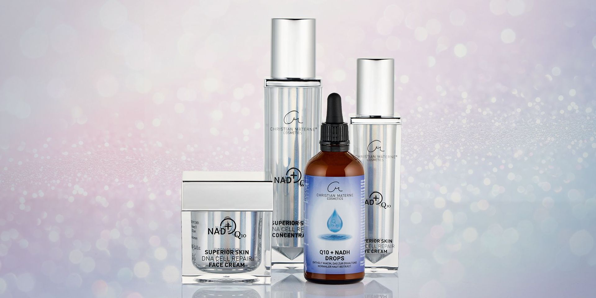 Der flüssige Energie-Boost für Haut, Stoffwechsel und tägliche Vitalität. Vier Kosmetikprodukte von Christian Materne: zwei silberne Pumpspender, ein braunes Tropfflaschenfläschchen mit blauem Etikett und ein silberner Cremetiegel.